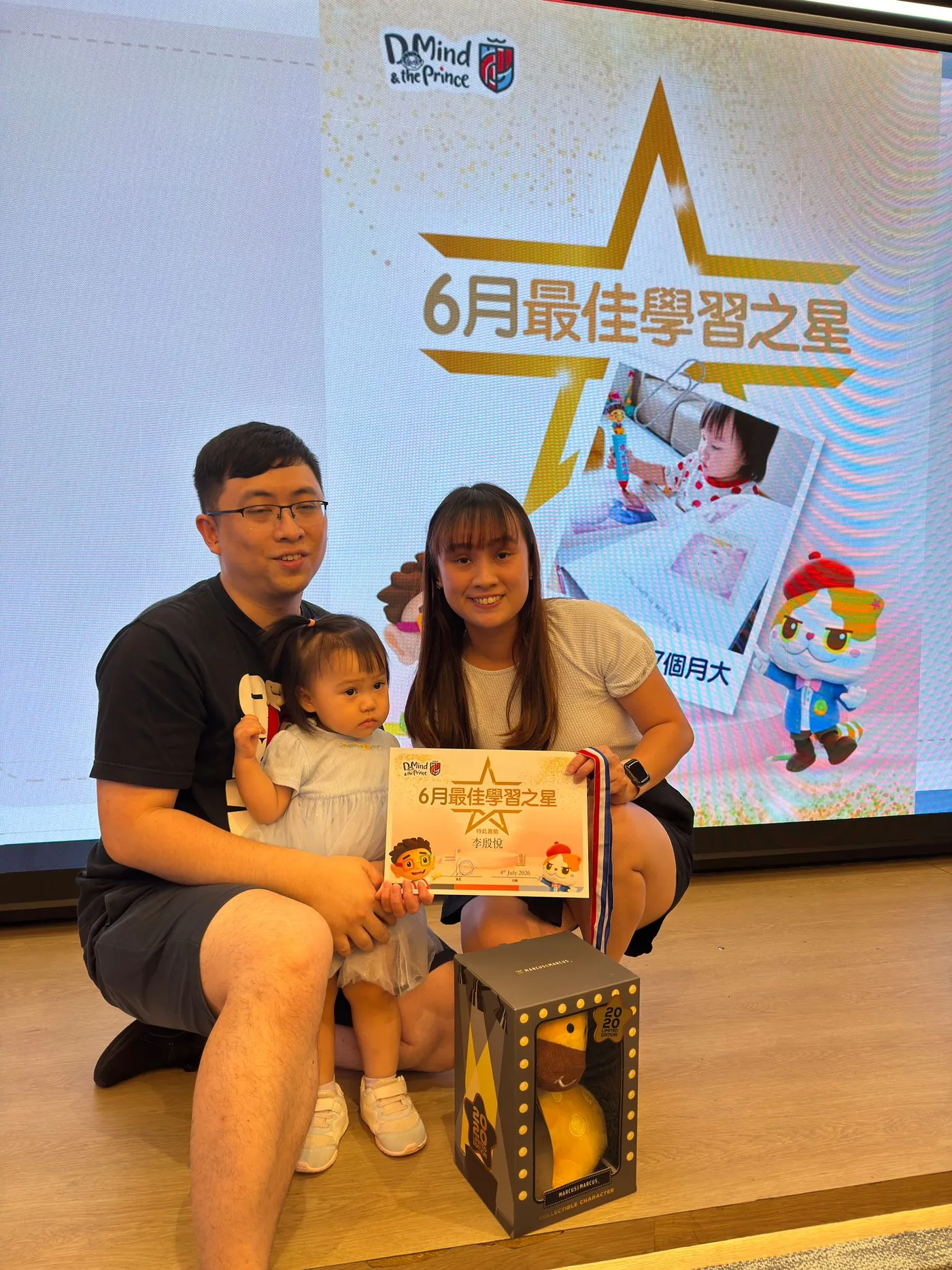 Parents and their child with a learning-star certificate.